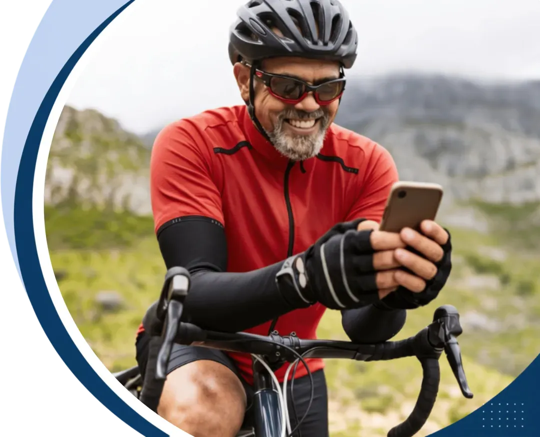 Man cycling on a mountain road while checking his phone