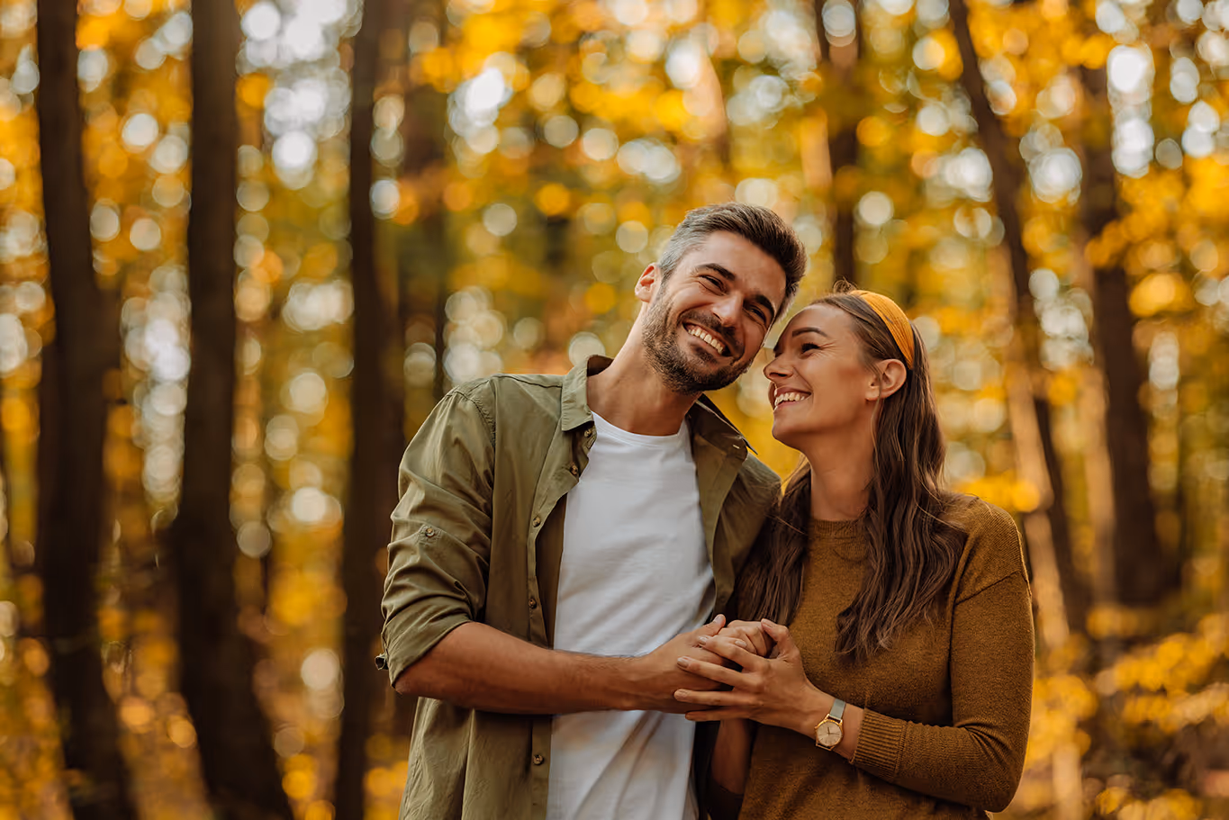 Couple holding hands in a beautiful autumn forest