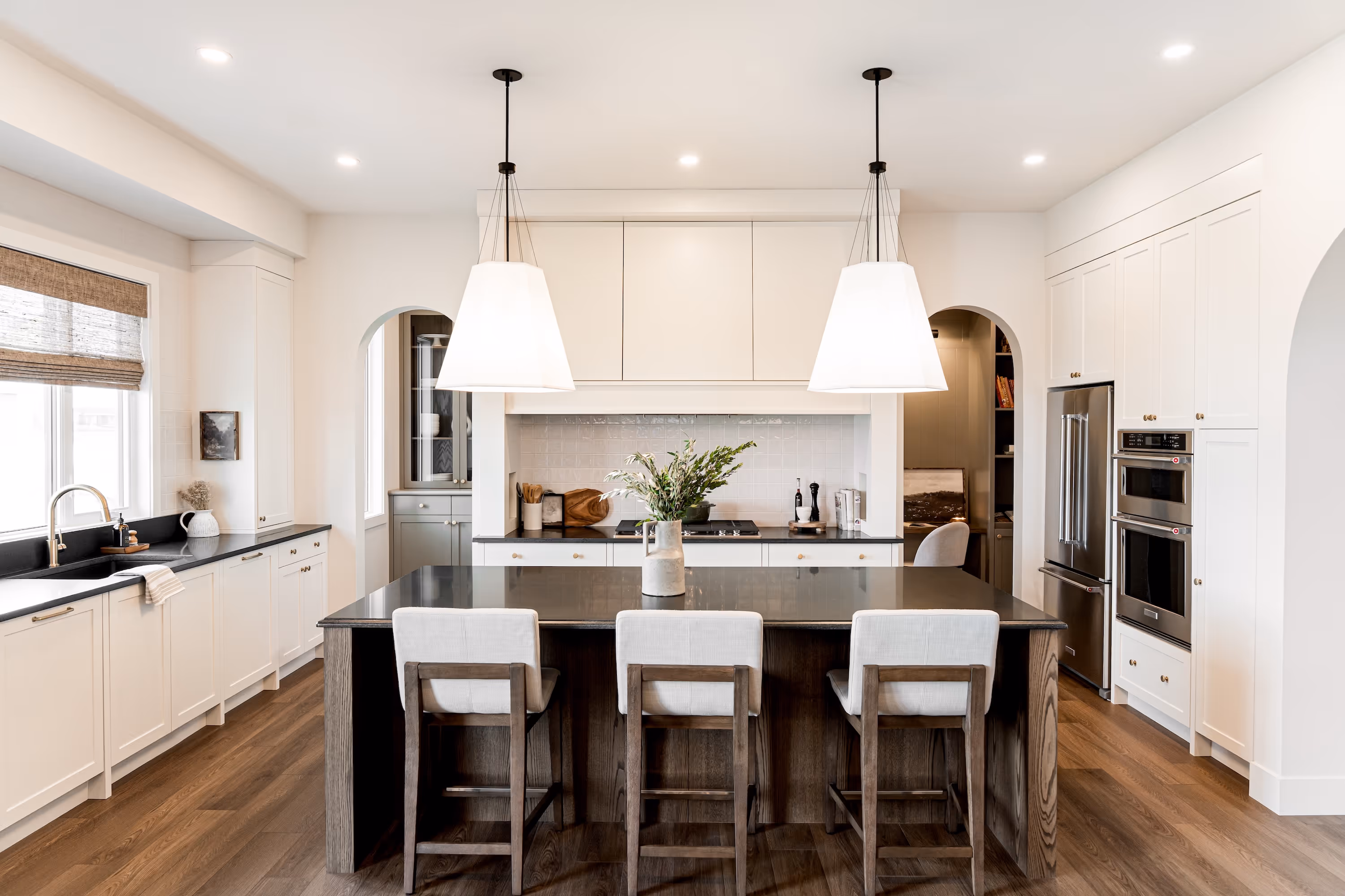 A large kitchen with a center island and white cabinets.