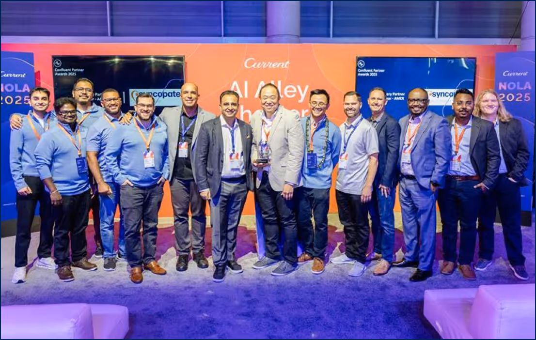 Group of fourteen men posing in front of an orange and blue AI Alley Partner event backdrop.