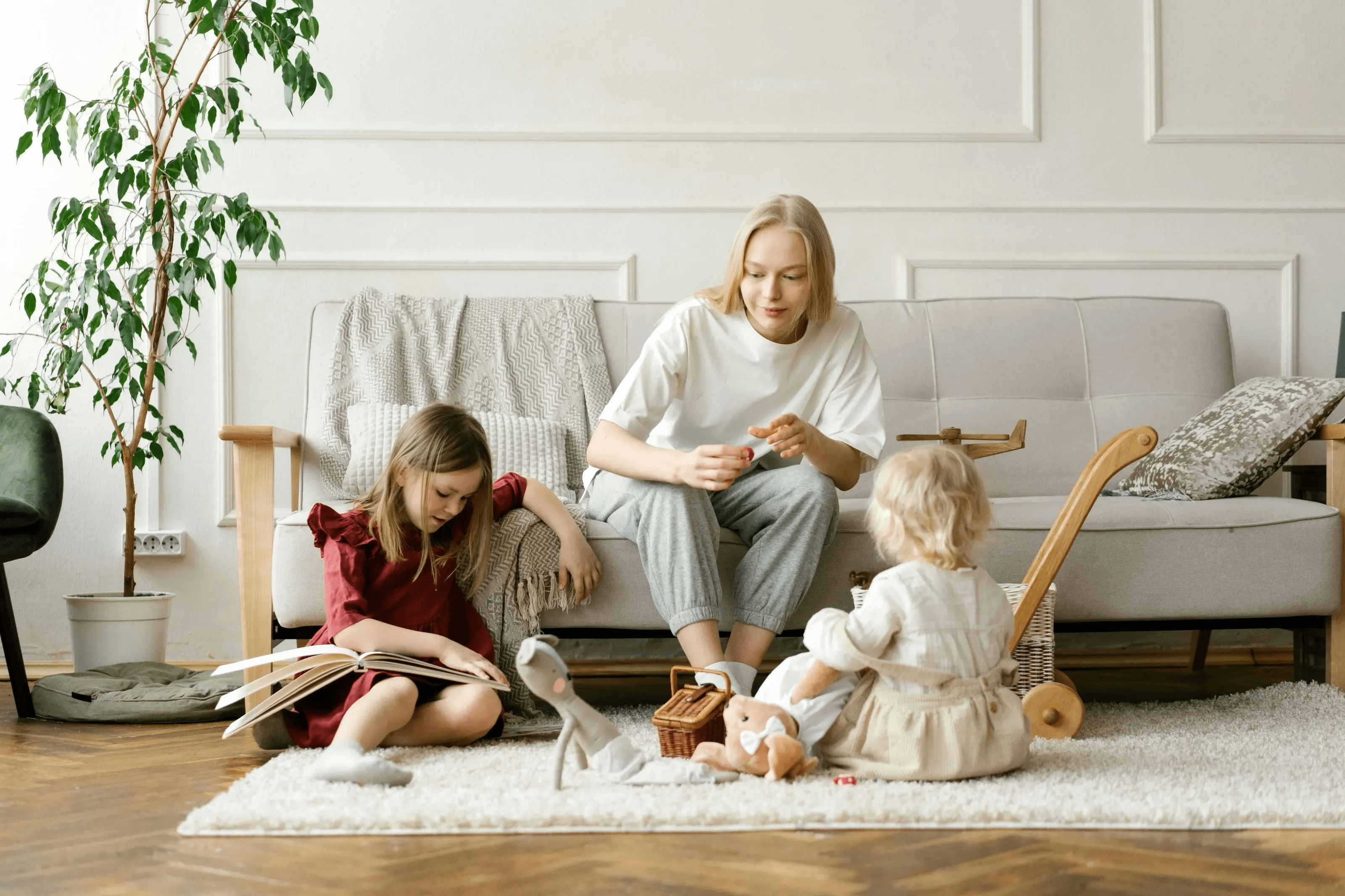 Mother sitting on a couch with her two daughters sitting on the floor