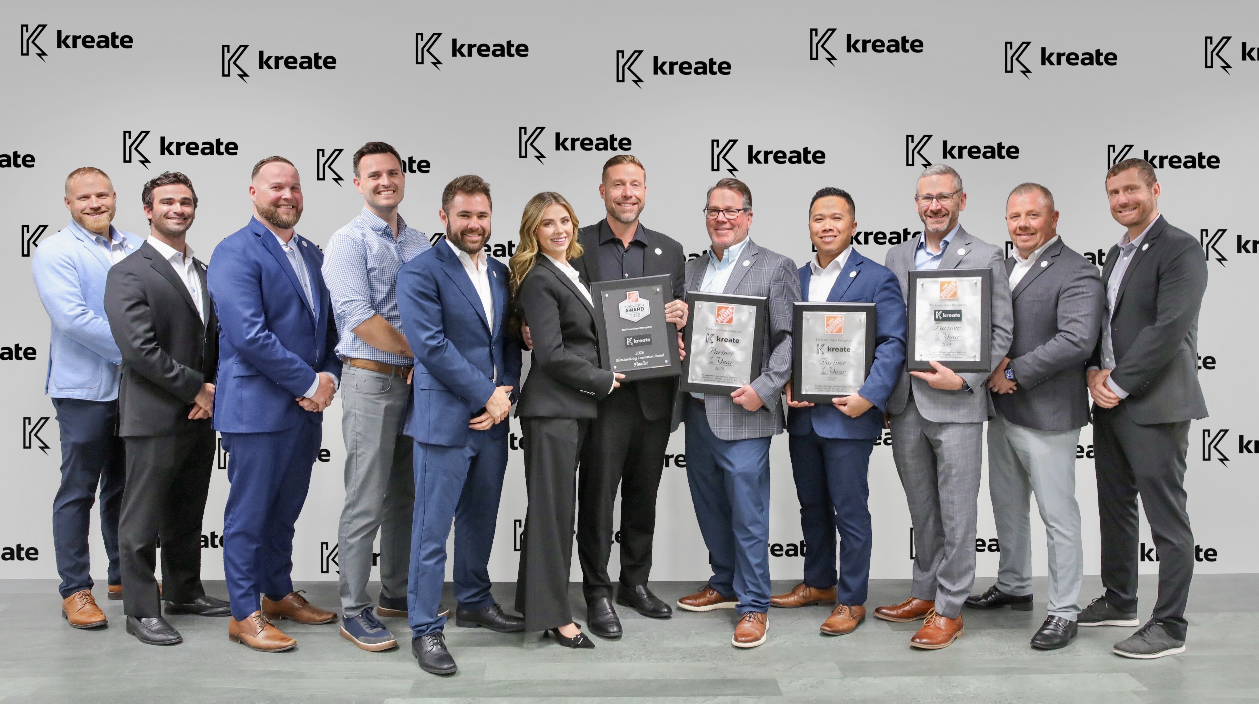 Kreate team holding The Home Depot Partner of the Year award plaques in front of a Kreate backdrop
