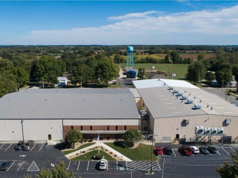 Aerial view of an industrial building with a water tower in the distance