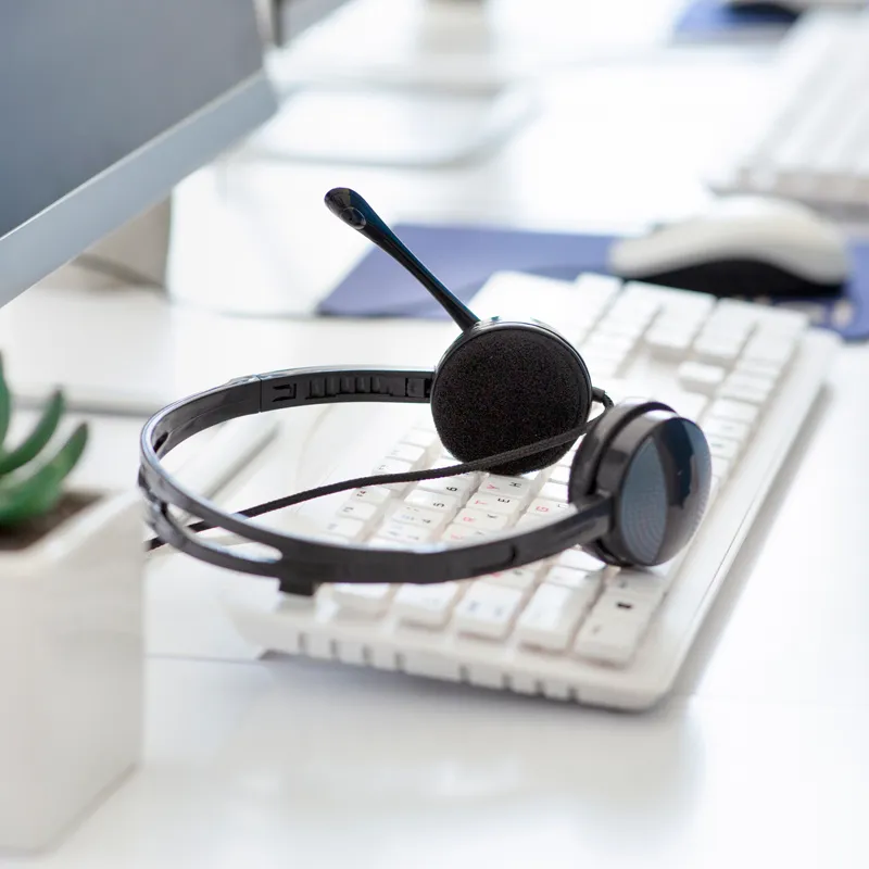 A set of headphones with a microphone resting on a keyboard. 