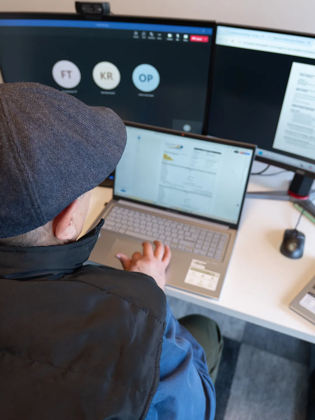 Jason from Quantum Staffing Solutions conducting a zoom interview on one monitor while looking at a job application on his laptop.