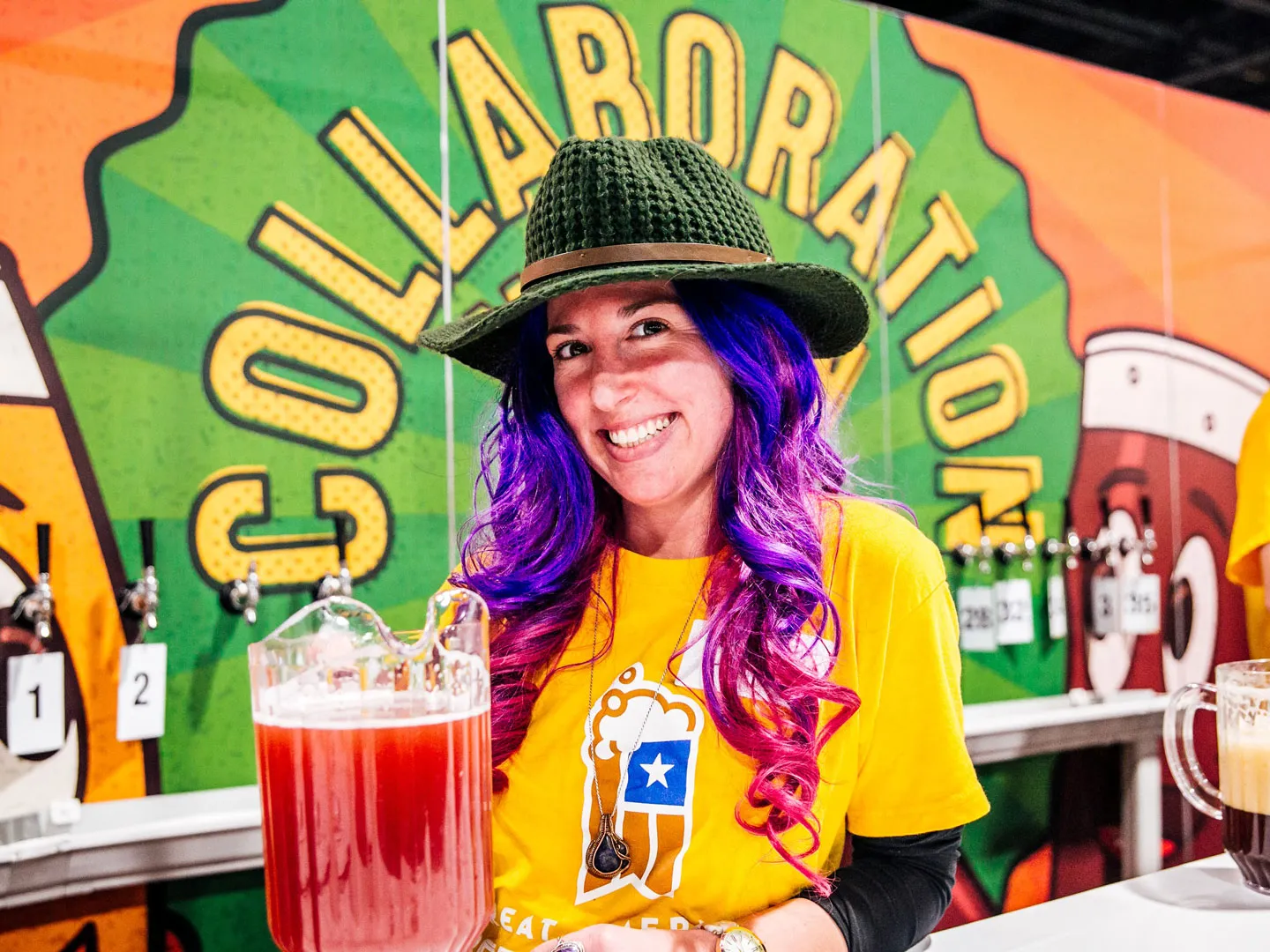 a beer-pouring volunteer smiling at the Collaboration booth at Great American Beer Festival. Image copyright Brewers Association 
