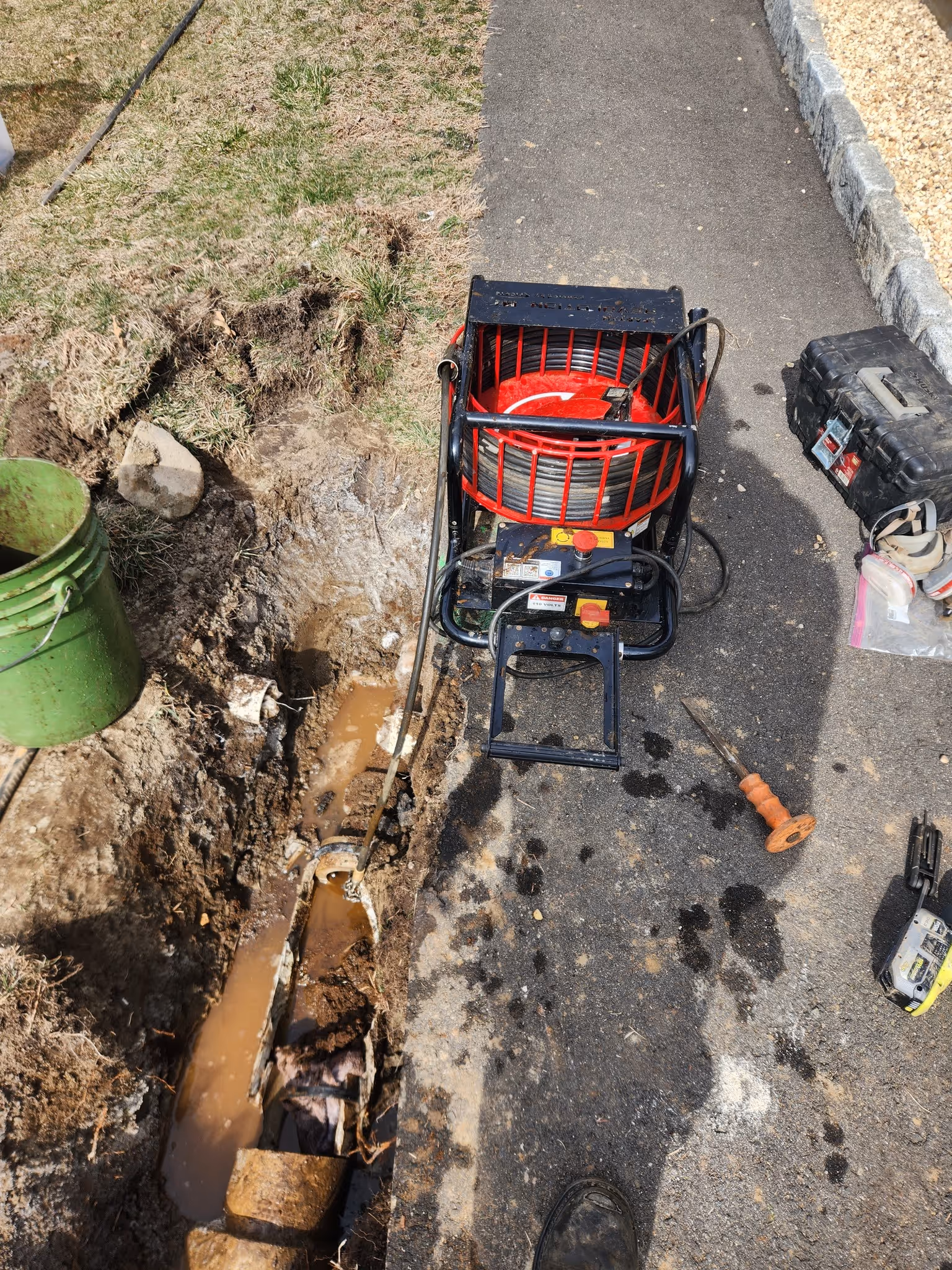Plumber in Greenwich, CT repairing broken sewer line with excavation and drain cleaning tools
