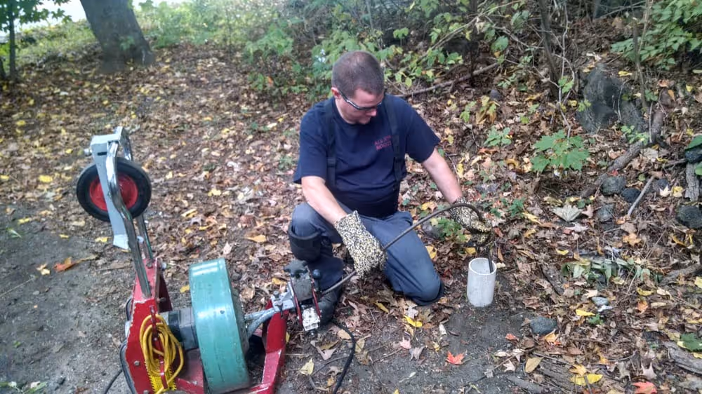 Emergency Plumber in Greenwich, CT performing drain cleaning outdoors with professional machine