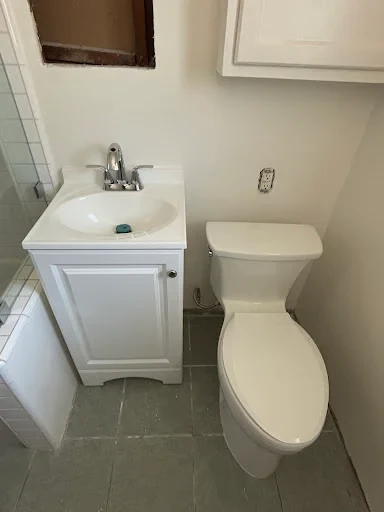 Installed toilet plumbing connection with clean PVC piping and branded cap in Norwalk CT