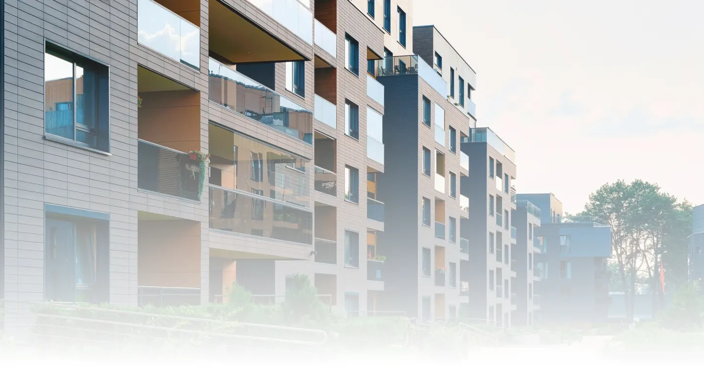 Modern multi-story apartment buildings with balconies and glass railings.