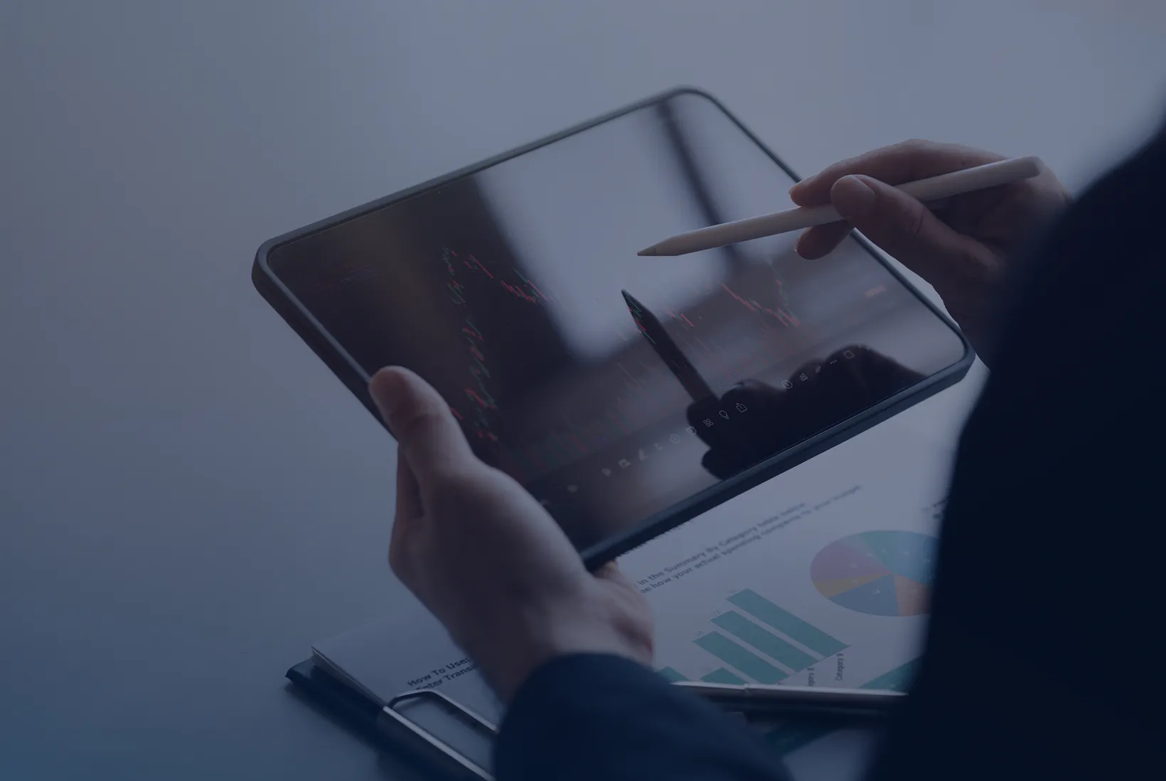 Investor holding tablet and reviewing portfolio documents