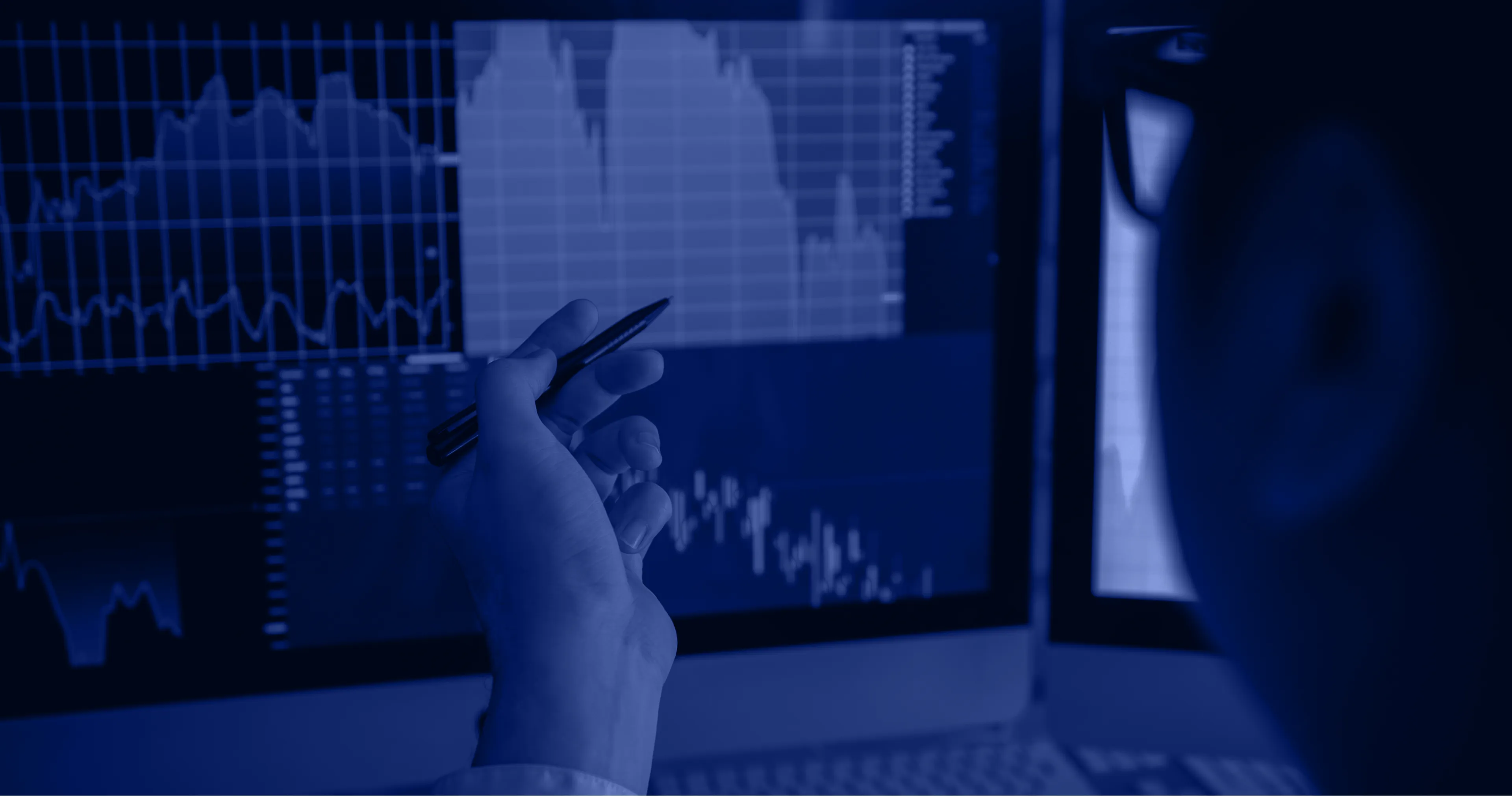 Investor analyzing data screens in a dark-themed financial environment