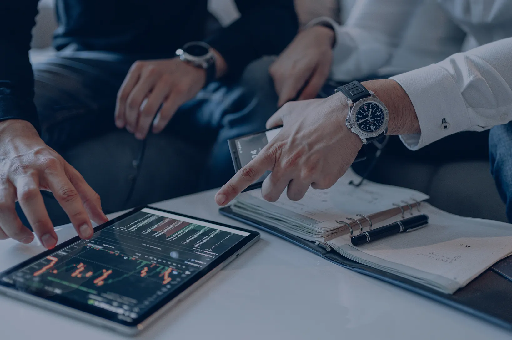 Hands working on laptop with financial data charts