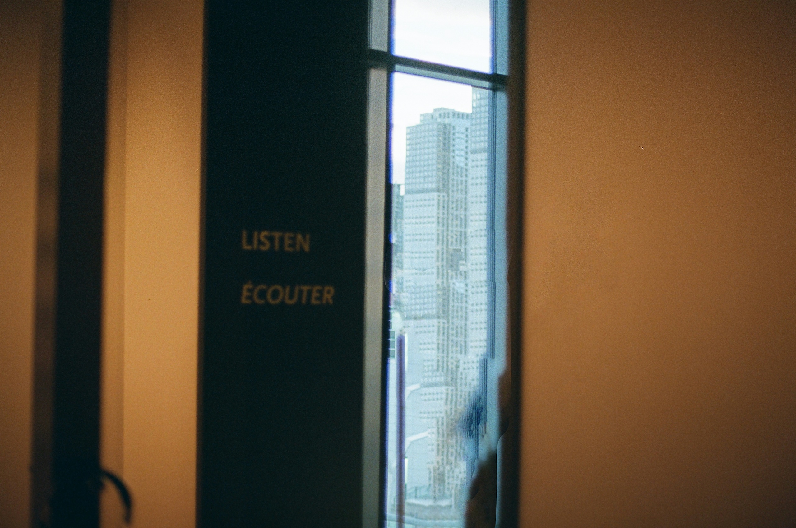 Warm auditorium interior with a large window overlooking the city