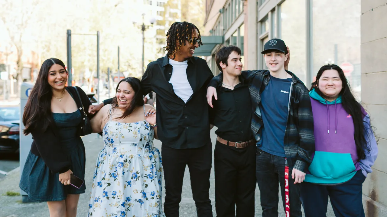 Diverse group of young friends smiling together on city street