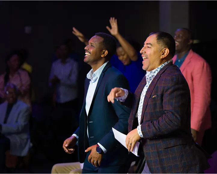 Two men laughing and enjoying themselves at an event or conference