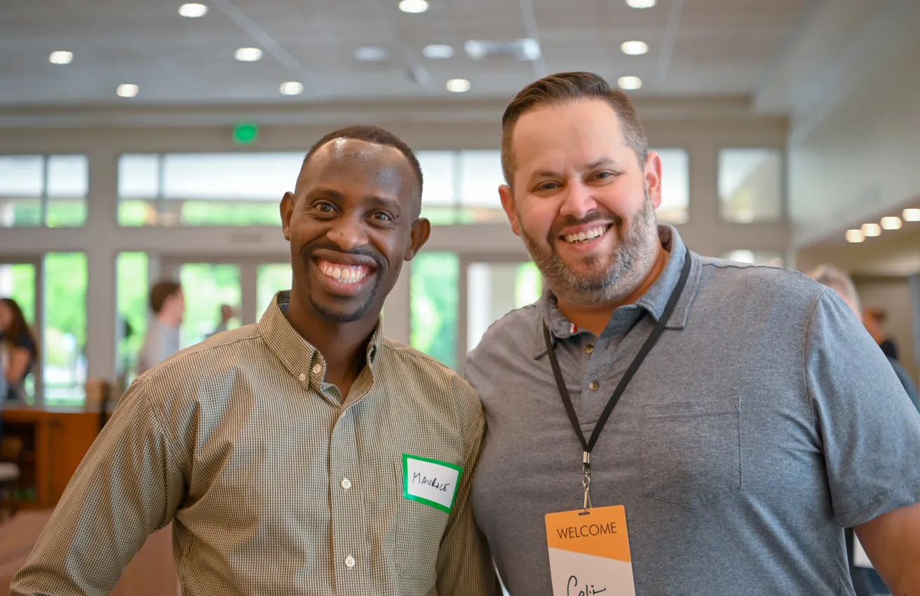Two smiling colleagues at a welcome event with name tags