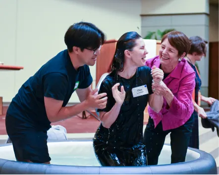 Three people laughing and interacting together in a playful setting