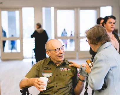 Veteran in military uniform talking with another person at an event