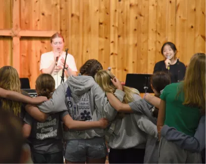 Students listening to speaker at wooden-paneled presentation or assembly