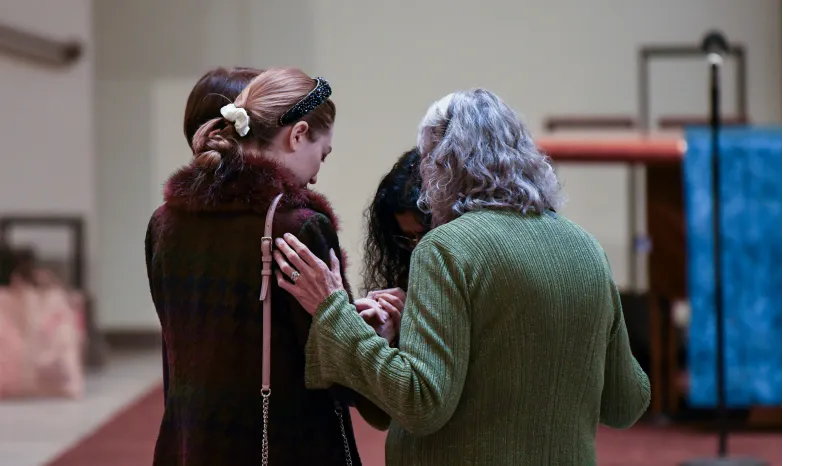 Two people standing together, one comforting the other with a gentle touch
