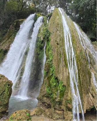 Cascading waterfall with white water and green moss-covered rocks
