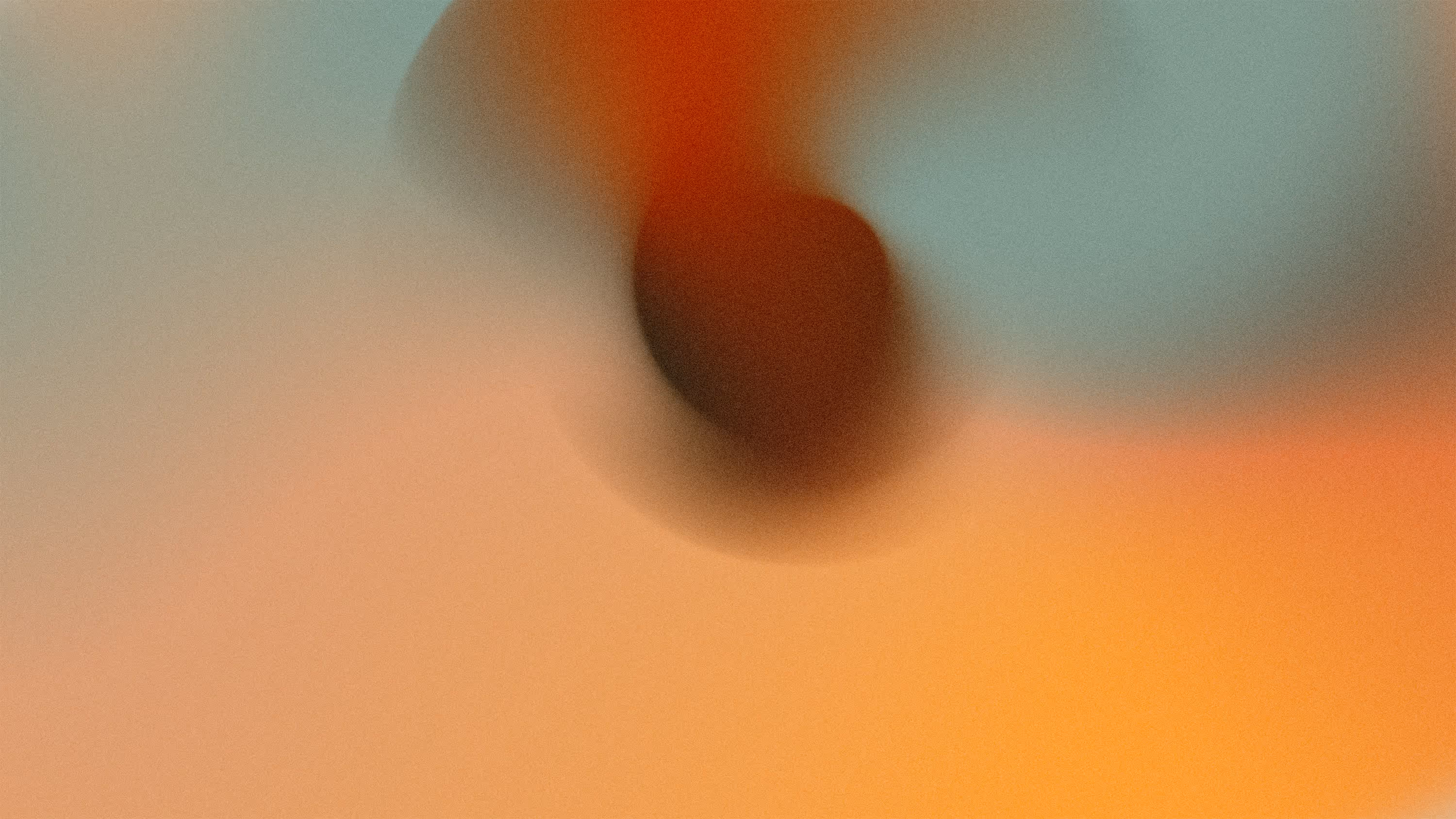 Blurred abstract image with warm orange and teal gradient colors.