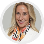 Smiling woman with long blonde hair wearing a white blazer and a colorful scarf.