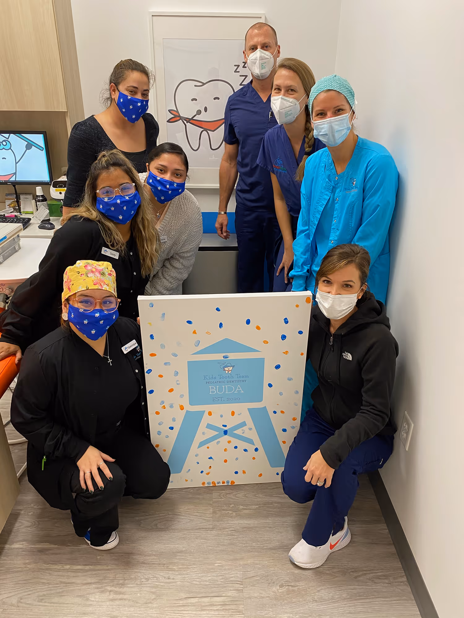 A group of people in scrubs and masks posing for a picture.