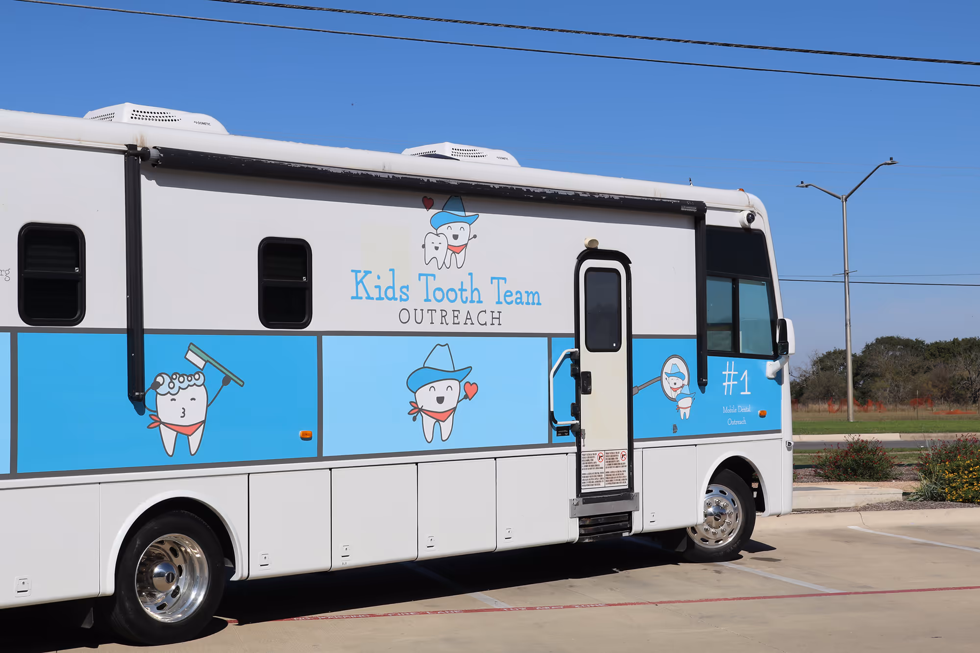 A white and blue bus parked in a parking lot.