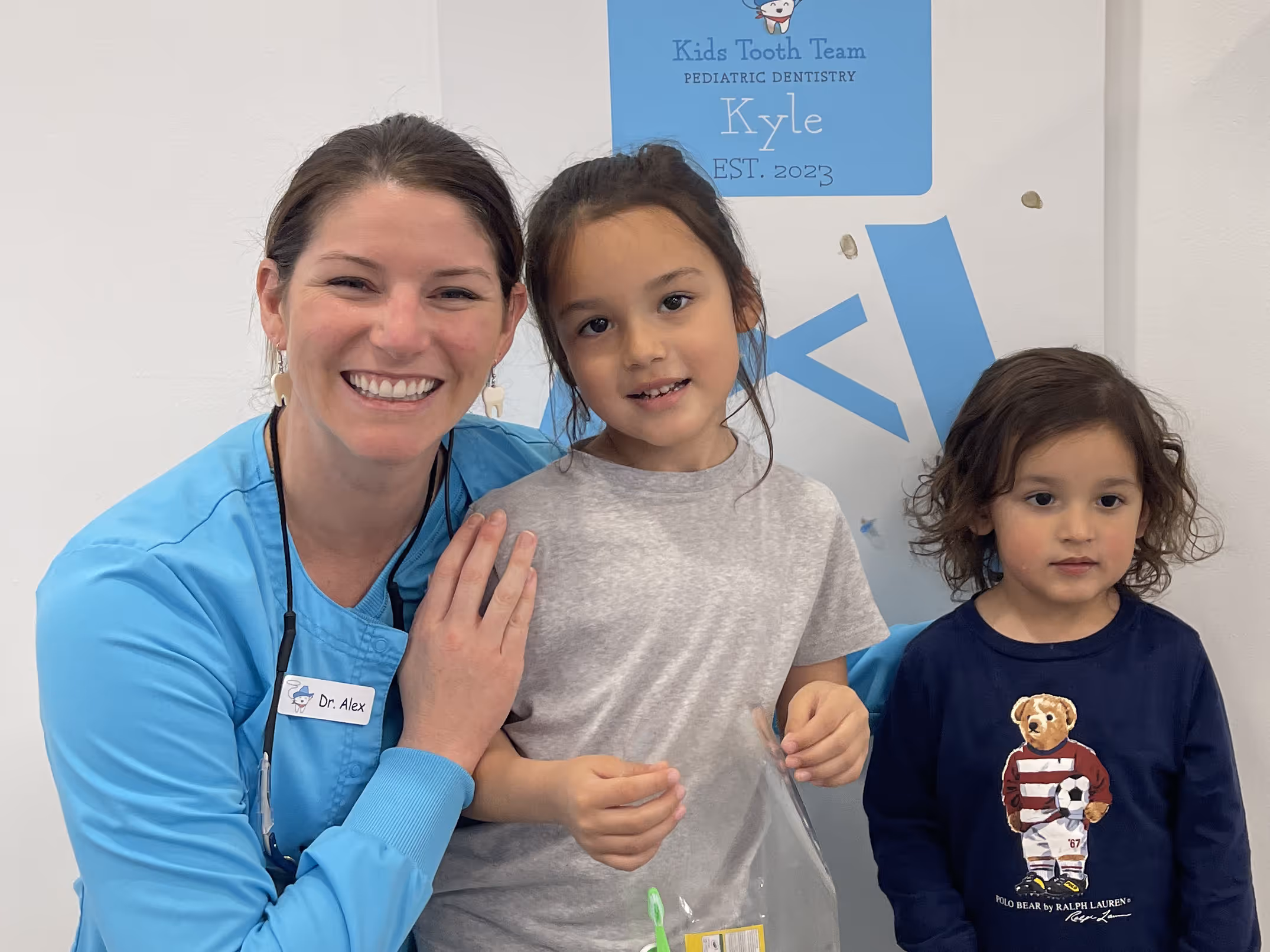 A woman and two children standing next to each other.