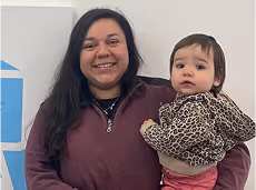 A woman holding a baby in her arms.