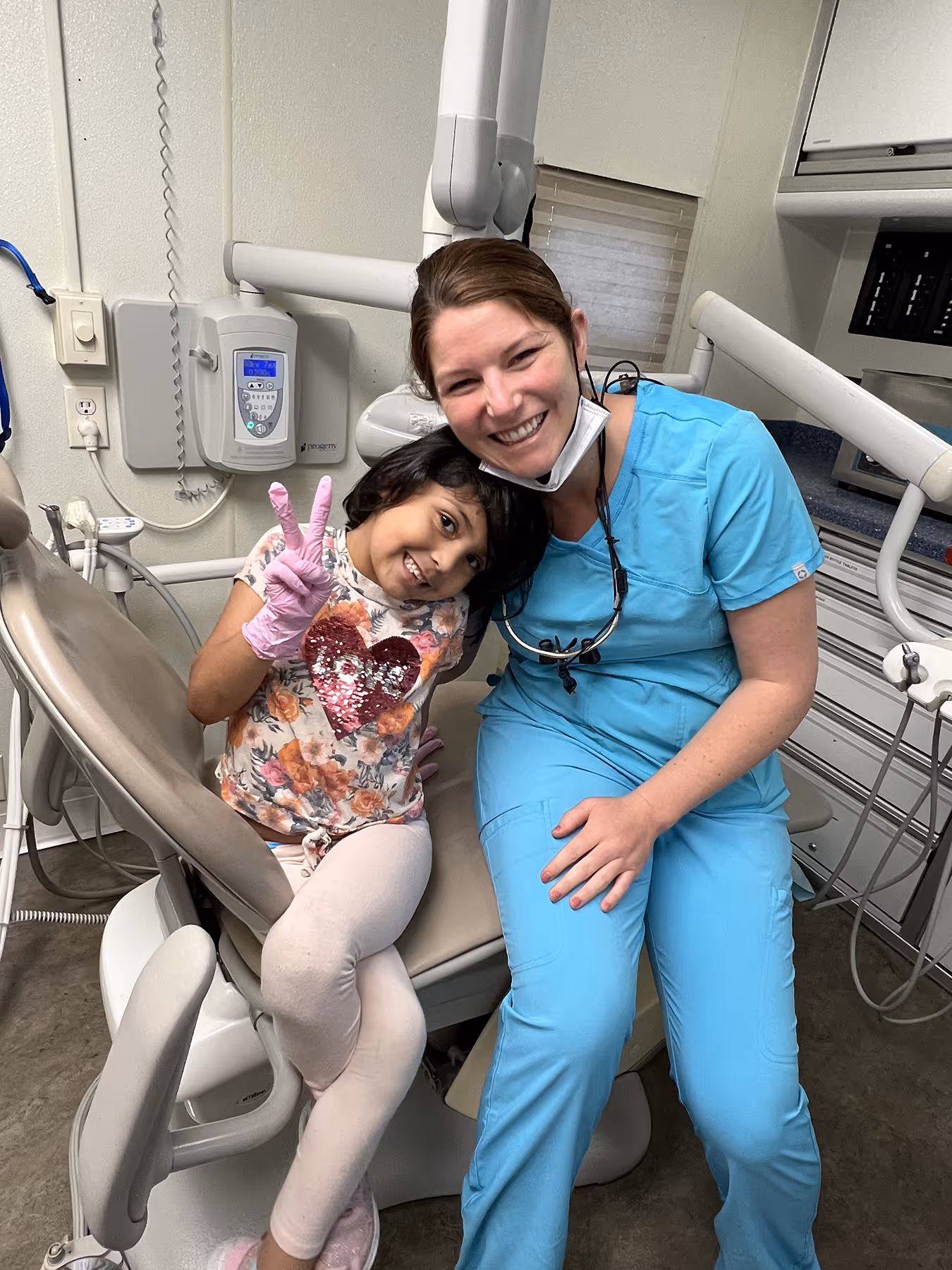 A woman and a little girl sitting in a dental chair.