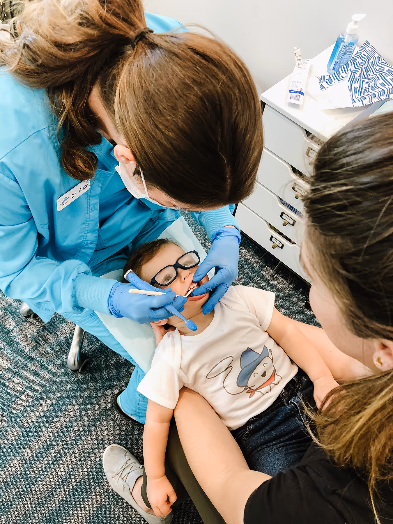 A little boy getting his teeth checked by a dentist.