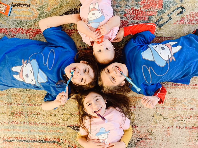 A group of young children laying on top of a rug.