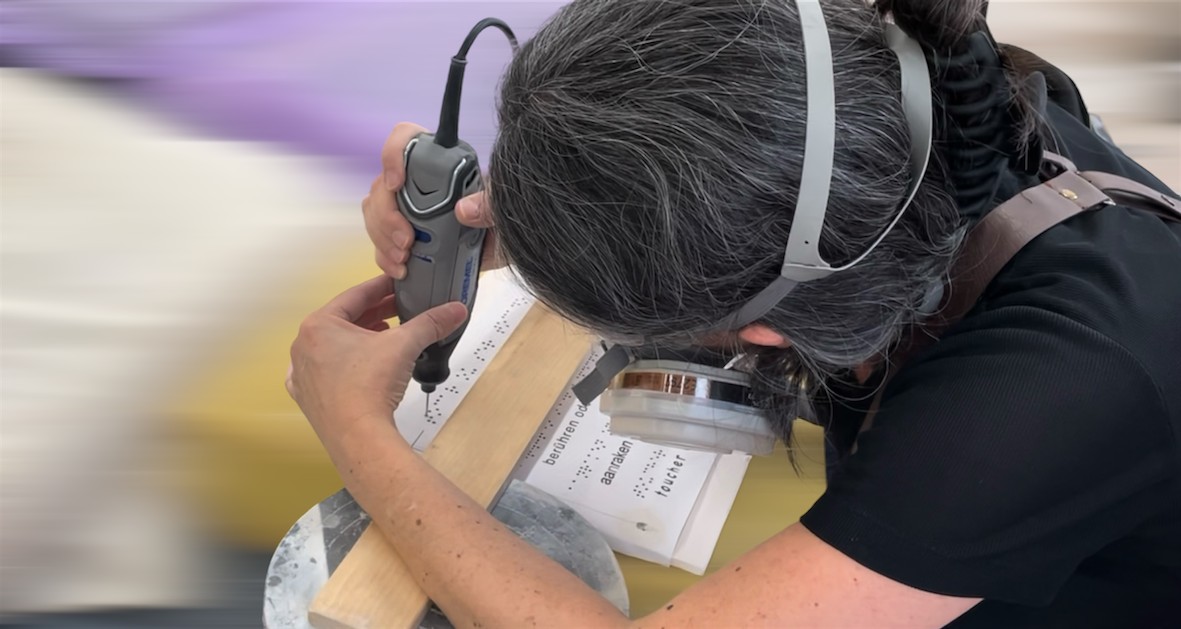 Foto da Artista a trabalhar na escrita em Braille