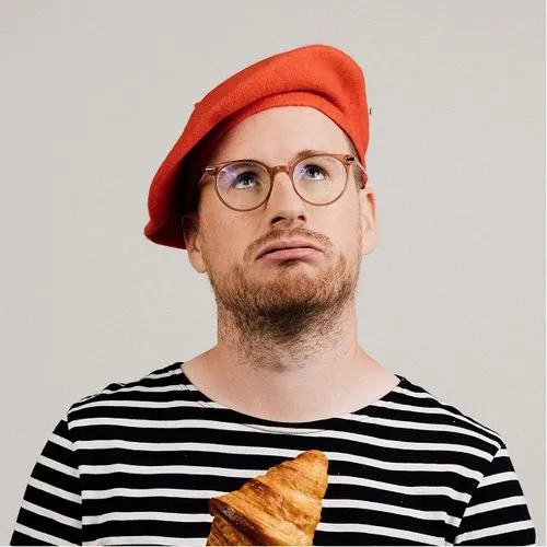Portrait of Paul Taylor with a beret and a croissant