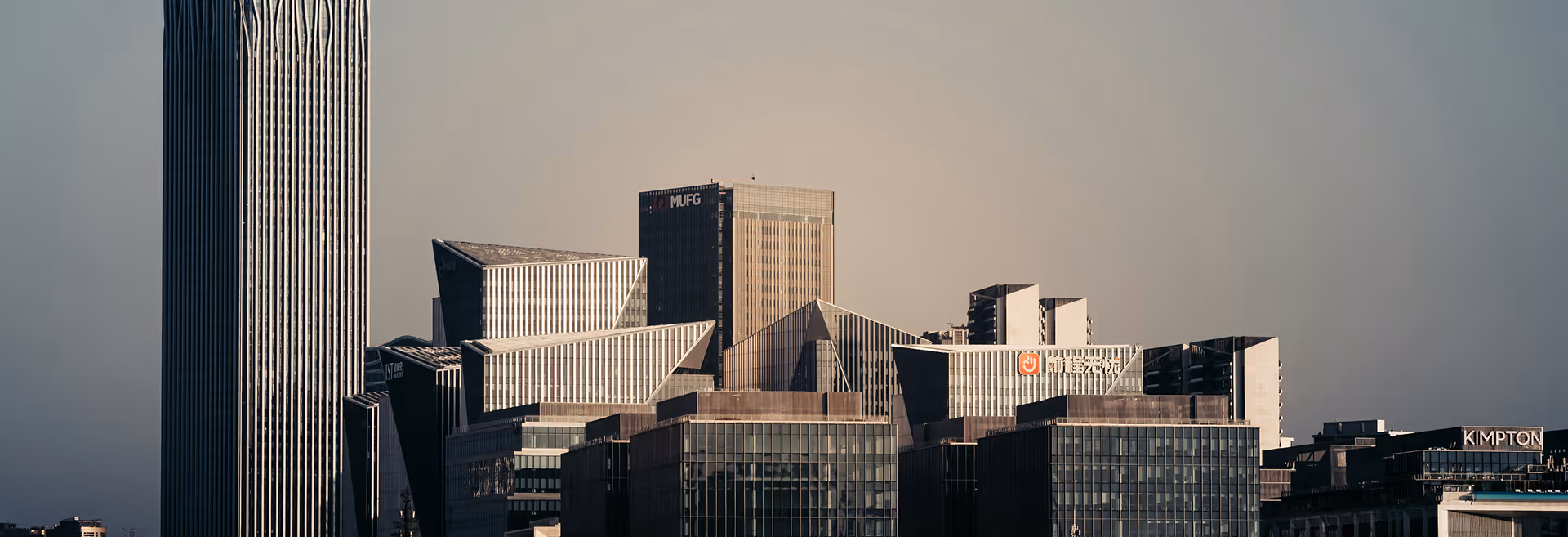 Skyline of modern skyscrapers under a clear sky. Tall, glass-clad buildings with varied geometric designs evoke a sense of urban sophistication.