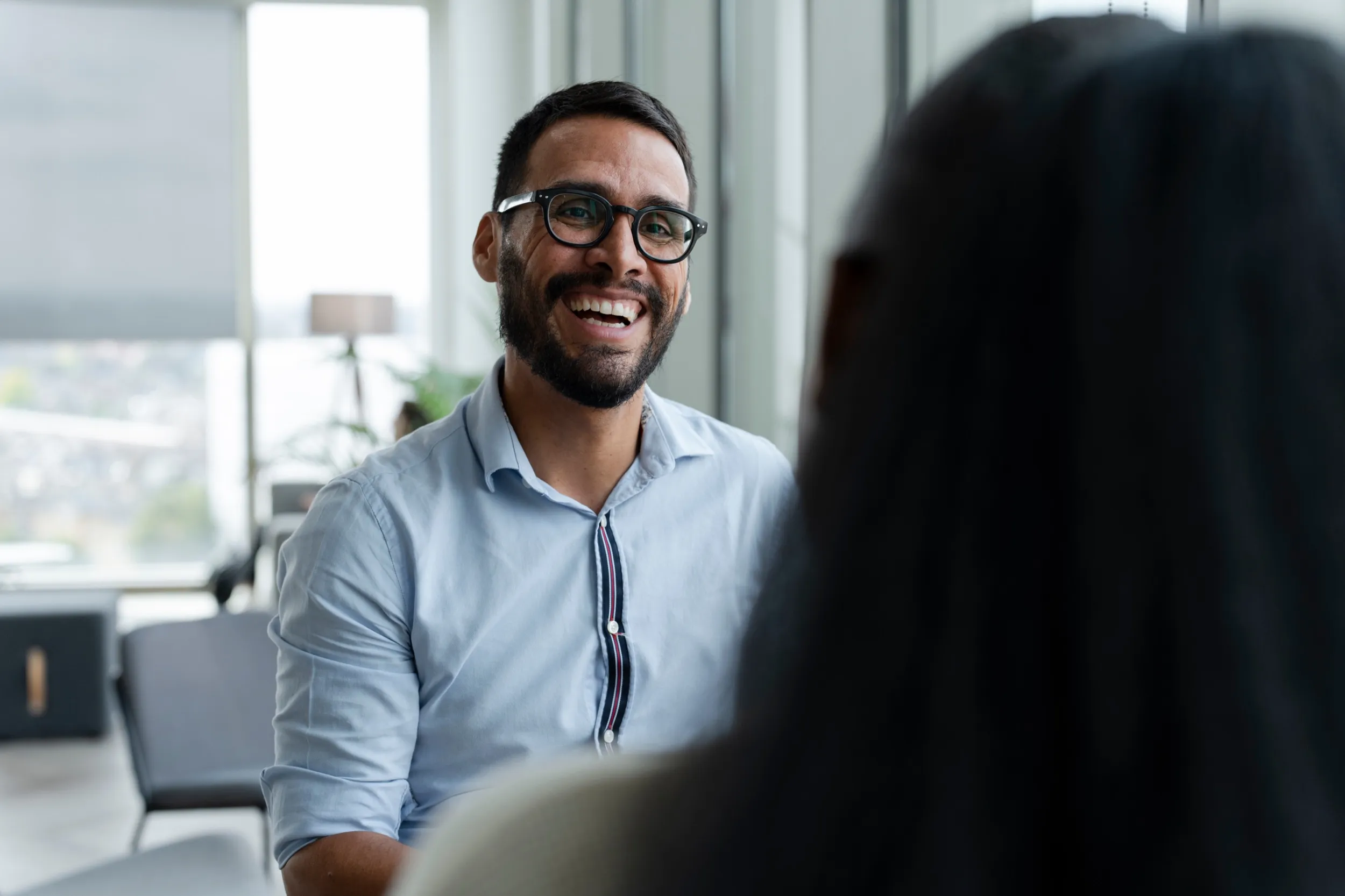 Smiling professional in glasses during a friendly office conversation