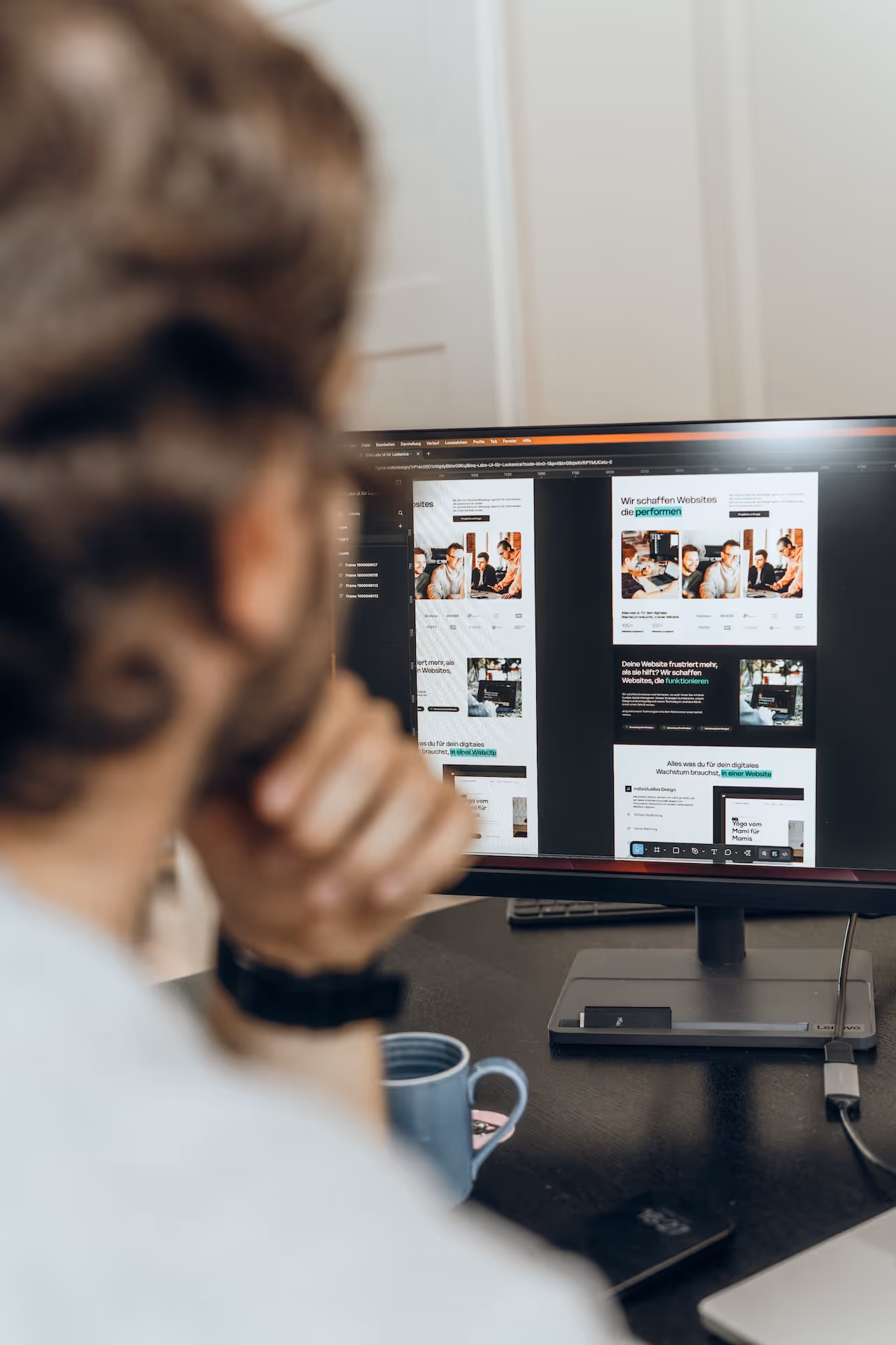 Designer einer webdesign agentur prüft am Bildschirm das Layout einer Website und verfeinert Struktur und visuelle Details.