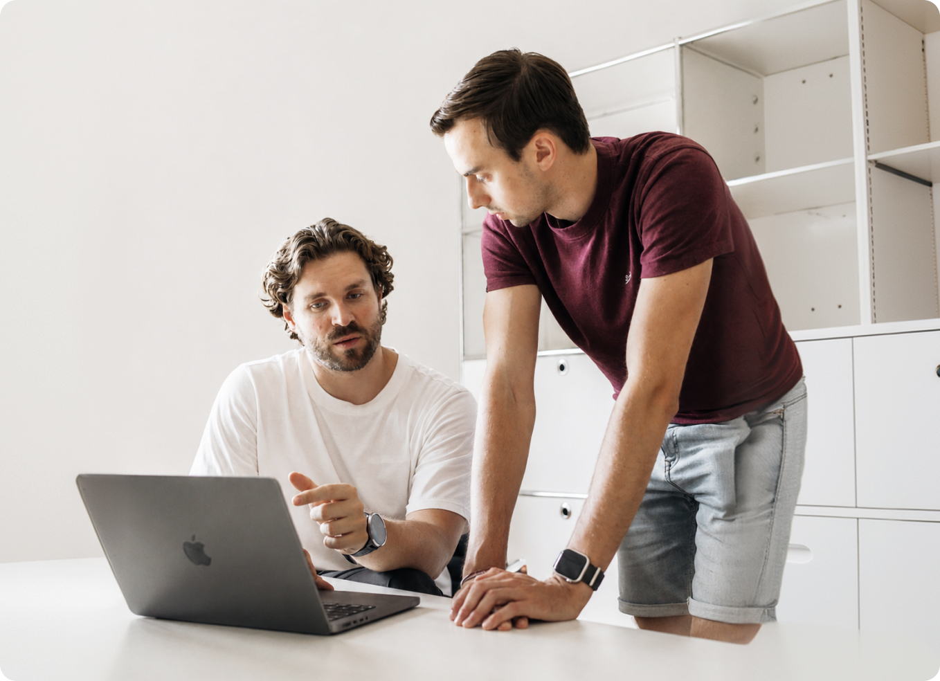 Zwei Mitarbeiter von Bloq Labs besprechen ein Projekt am Laptop
