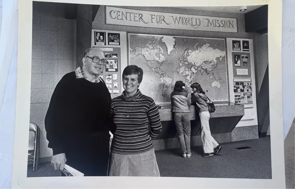 A men and a women standing in front of a map.
