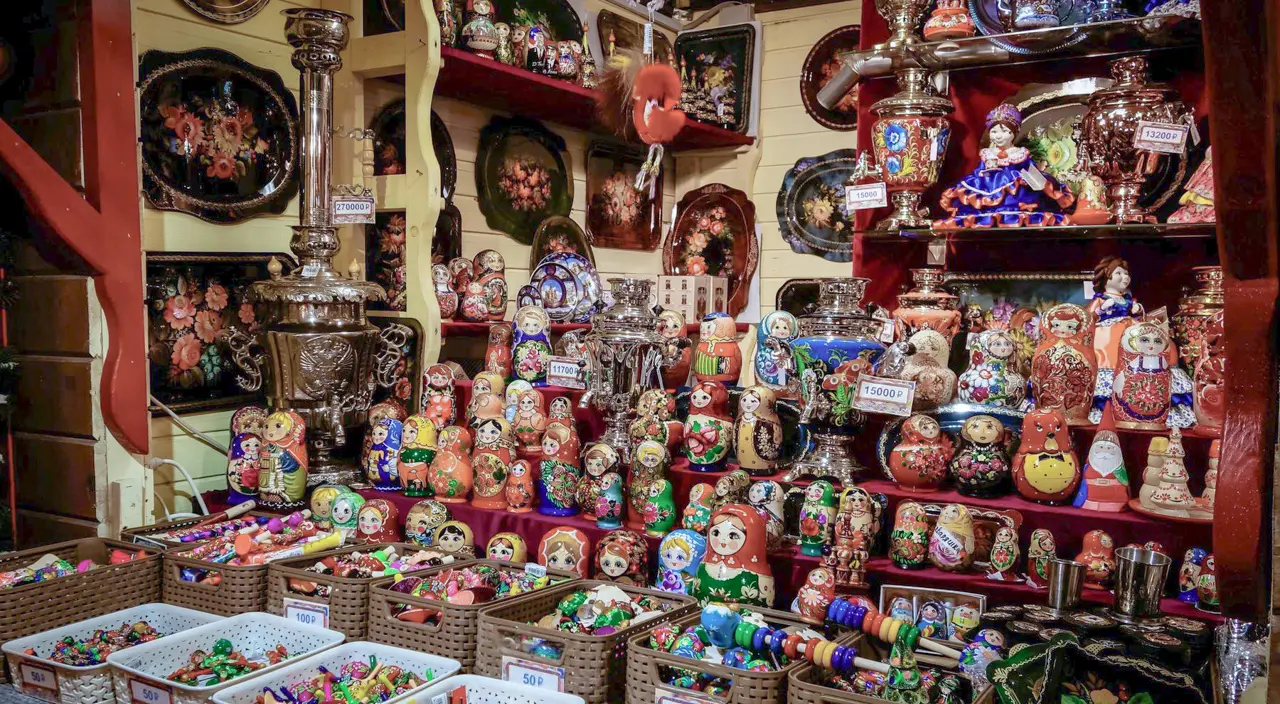 Rua Arbat. Vitrine com souvenirs russos tradicionais, incluindo bandejas de Jostovo, matrioshkas e um samovar.