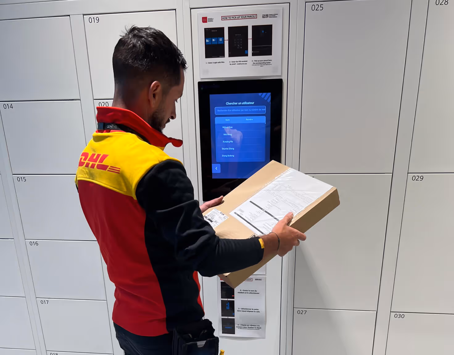DHL delivery worker holding a package and using a digital locker system.
