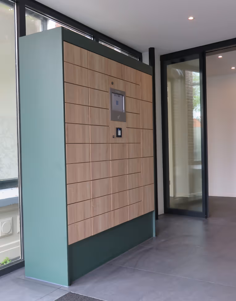 Modern indoor parcel locker unit with wooden doors and a central digital interface, next to glass doors in a tiled room.