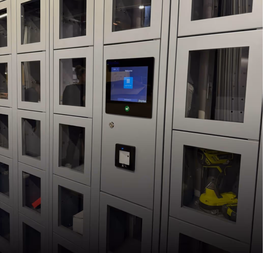 Gray vending machine lockers with a touchscreen interface and a visible yellow power drill inside one locker.