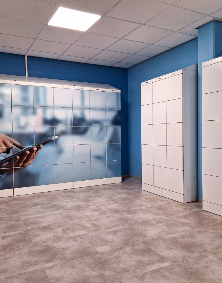 Room with white lockers and blue walls, one locker showing a blurred image of hands using a tablet.