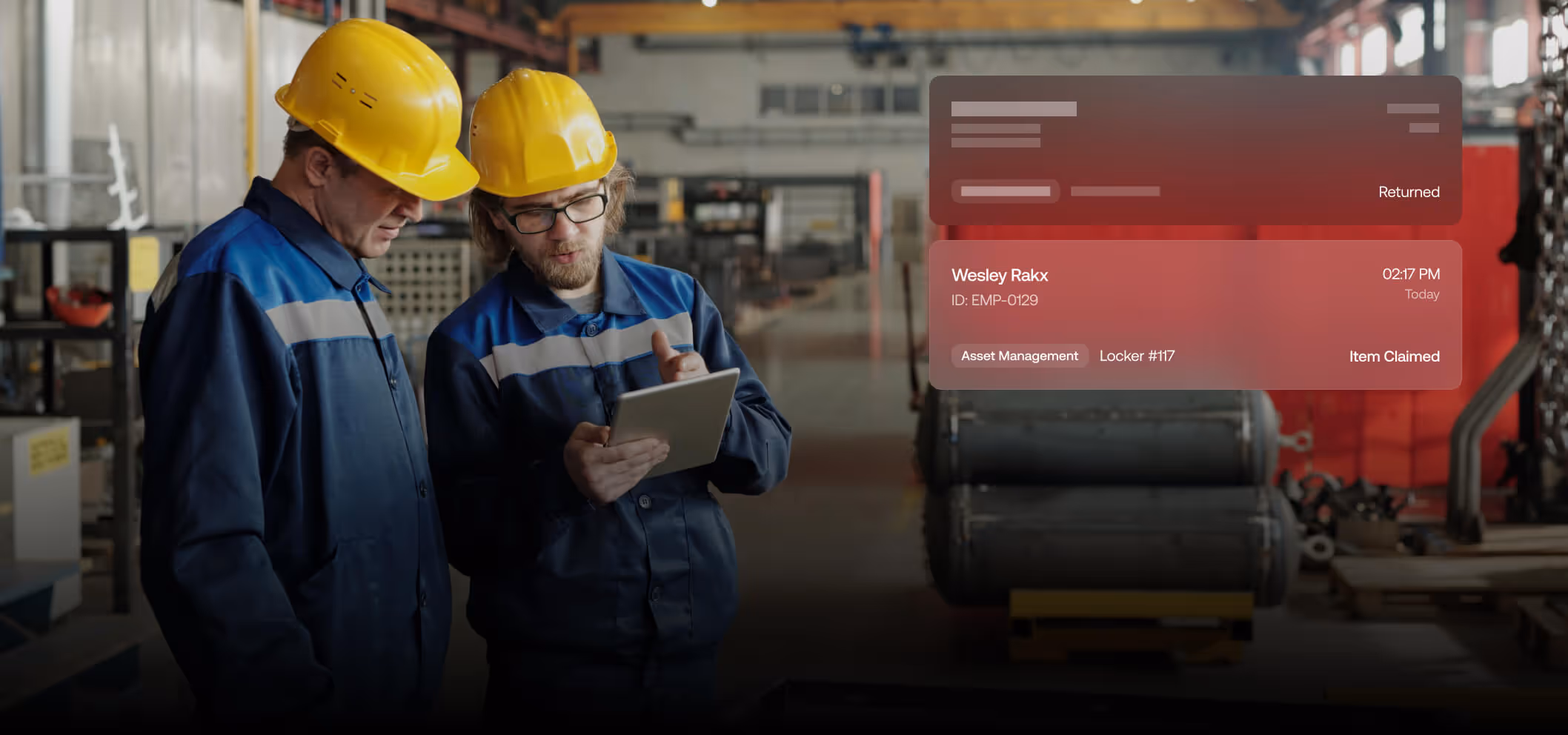 Two factory workers in blue uniforms and yellow helmets looking at a tablet with a digital interface showing asset management details.