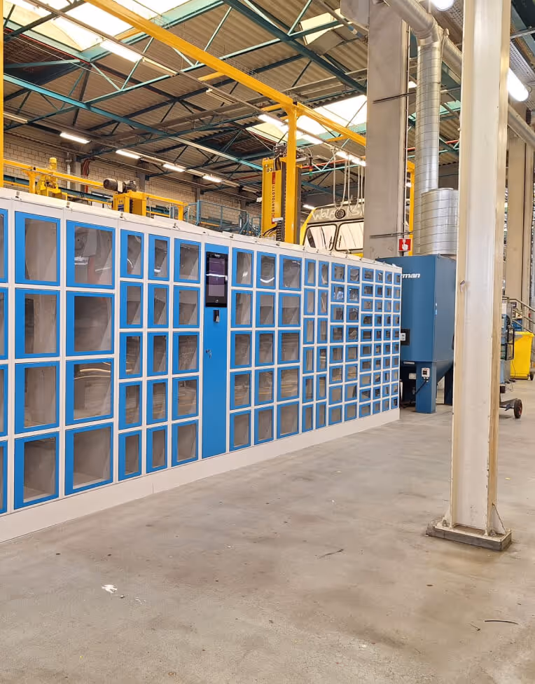 Industrial storage unit with multiple blue and white compartments in a factory setting.