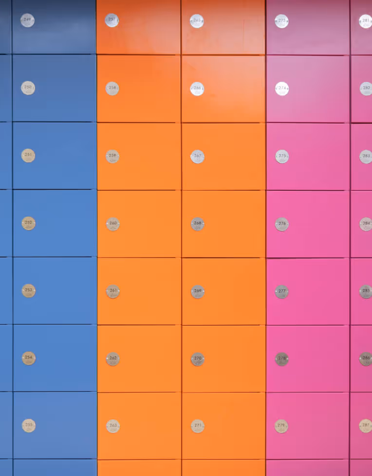 Rows of colorful lockers in blue, orange, and pink, each with a round numbered silver knob.